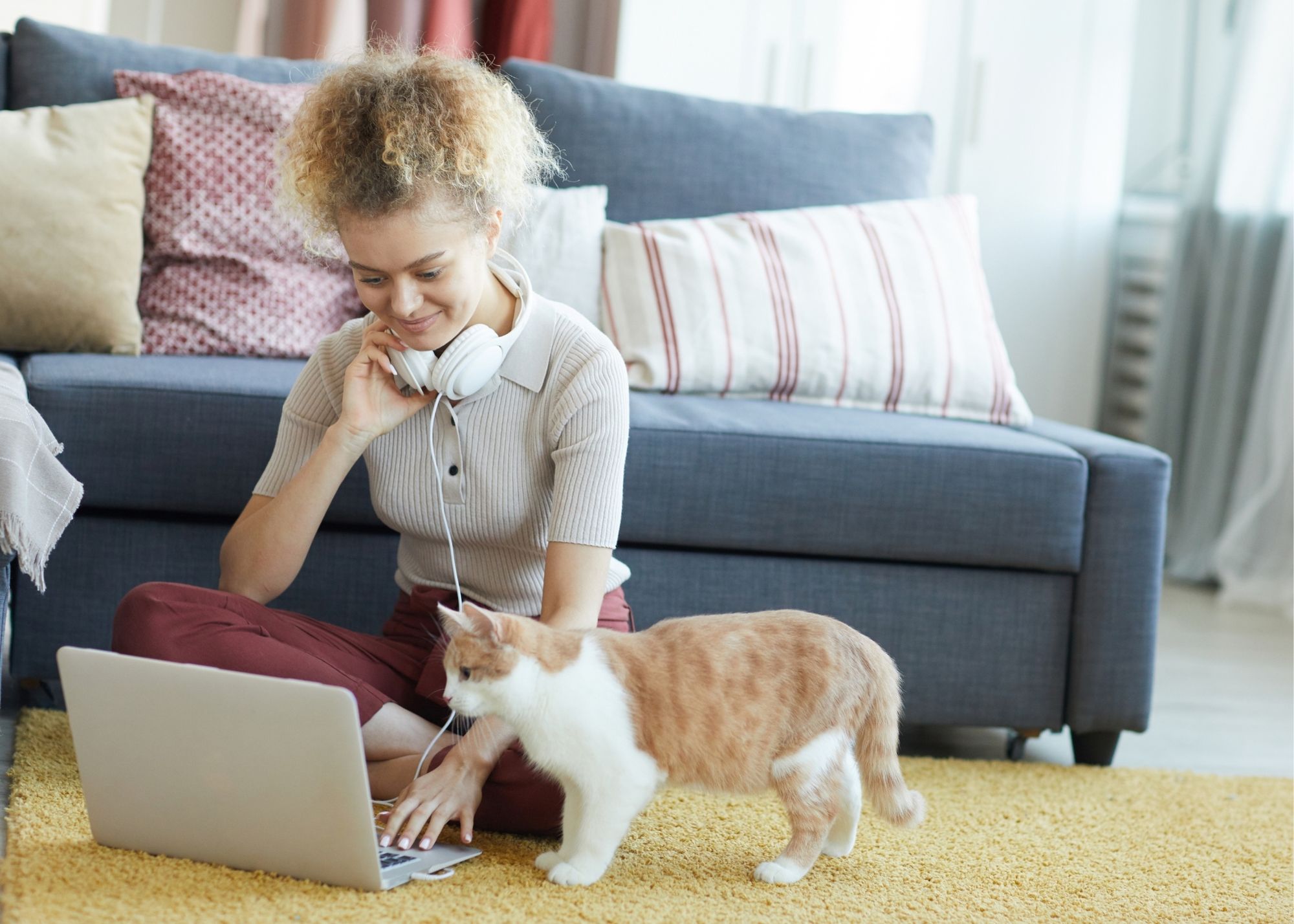 woman with headphones and a cat learning how to create a website on WordPress